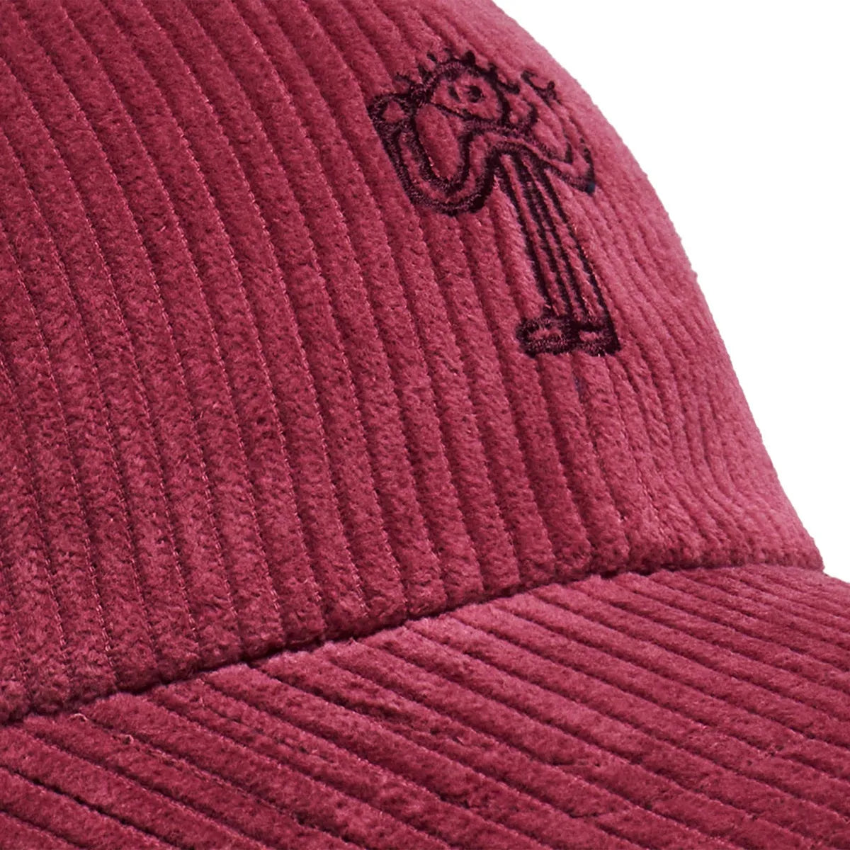 Détail de la broderie noire représentant un personnage à l’œil stylisé sur la casquette Bask in the Sun Eye