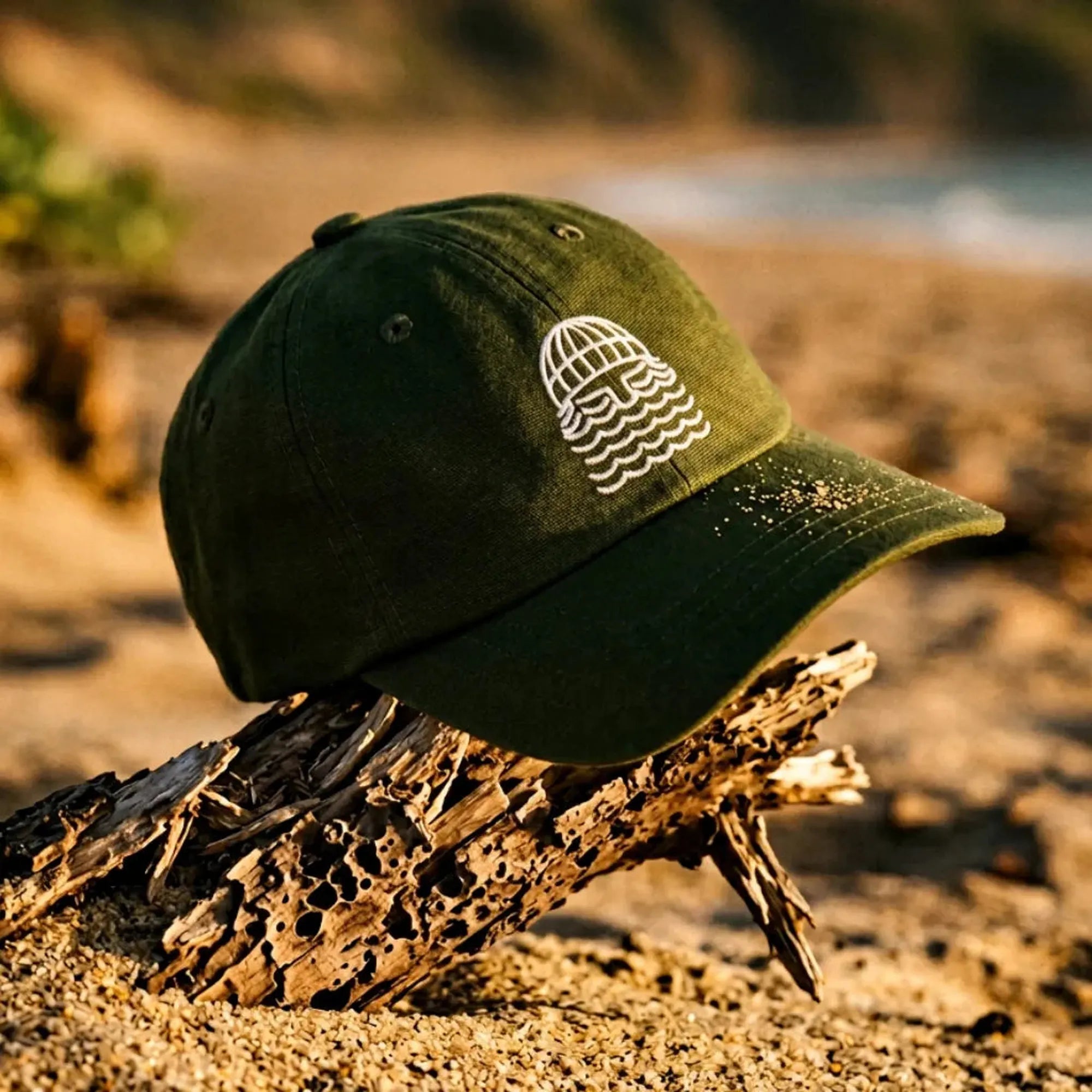 caasquette kaki avec barbu style bask in the sun brodé blanc posé sur le sable