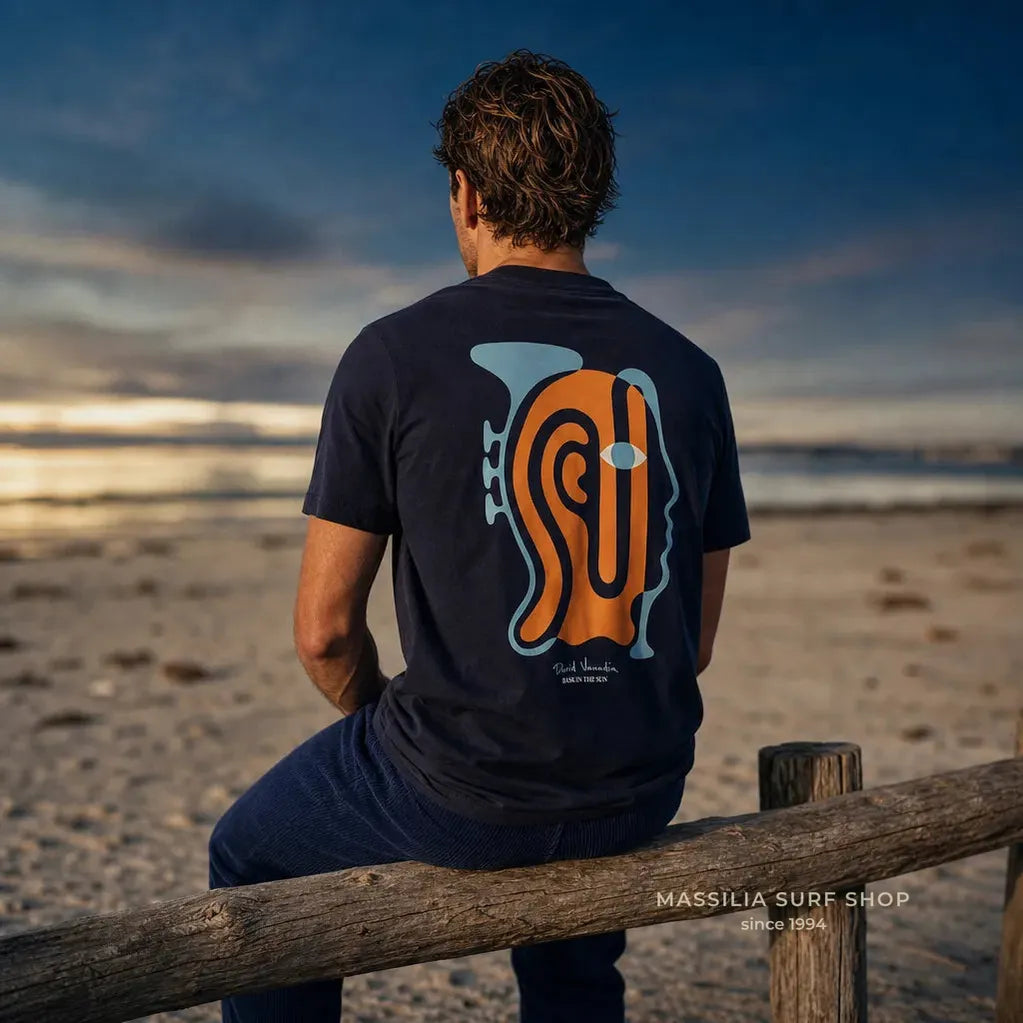 tss shirt blau marine vue de dos porté par un homme sur la plage avec motif jaz man stylisé