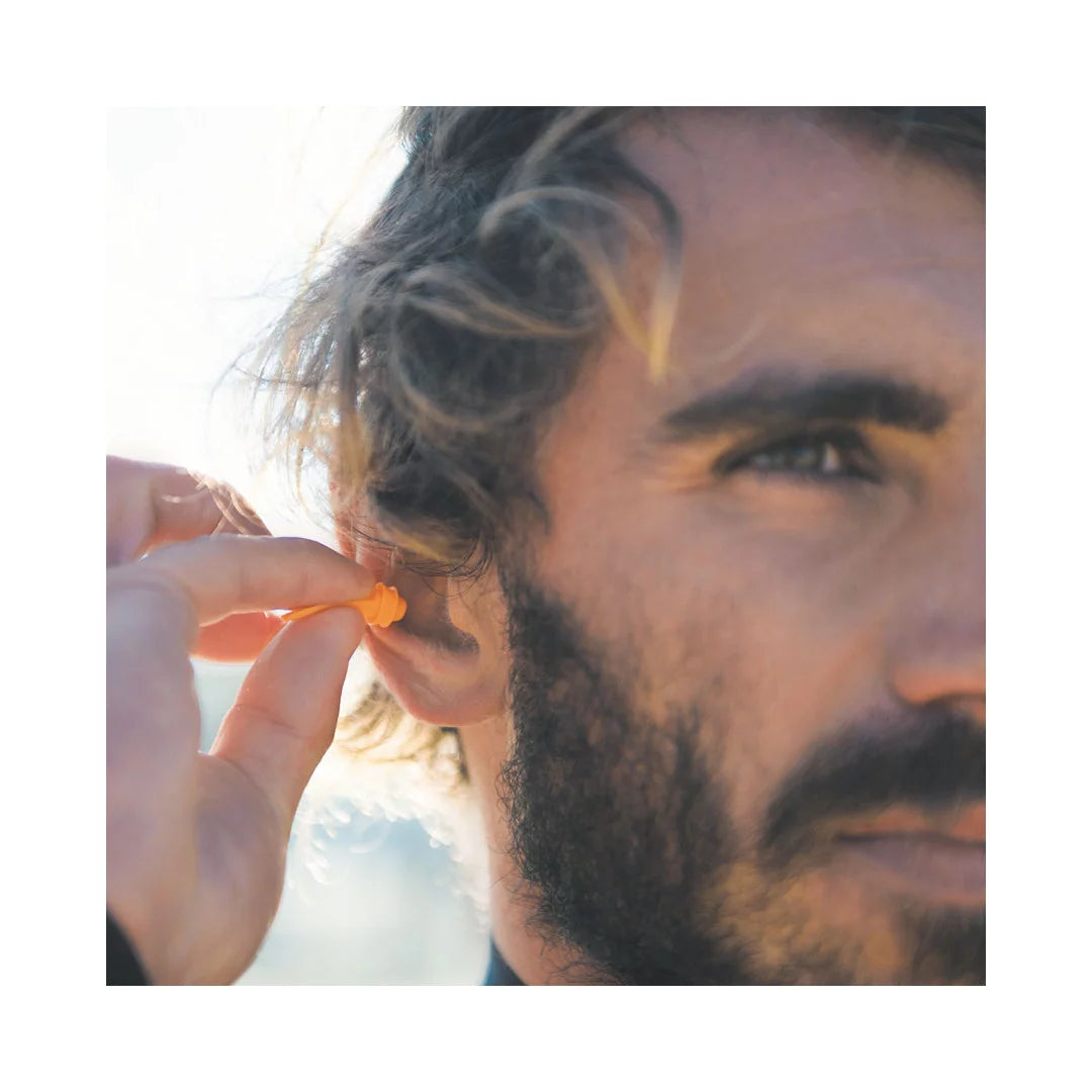 homme surfeur en train de mettre oucon dans son oreille lifestyle surf