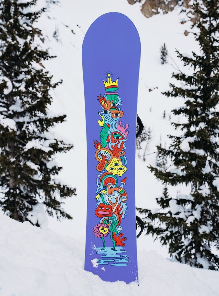 snowboard planté dans la neige vue semelle violette et dessin multicolore