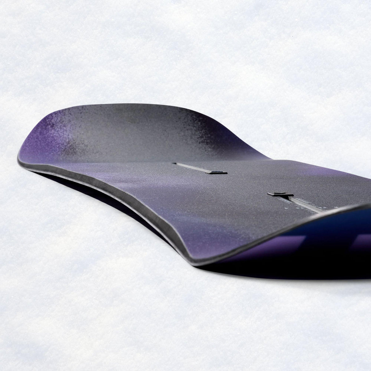 Carre du snowboard observée de côté, révélant le relevé du nose et les différentes couches de la construction