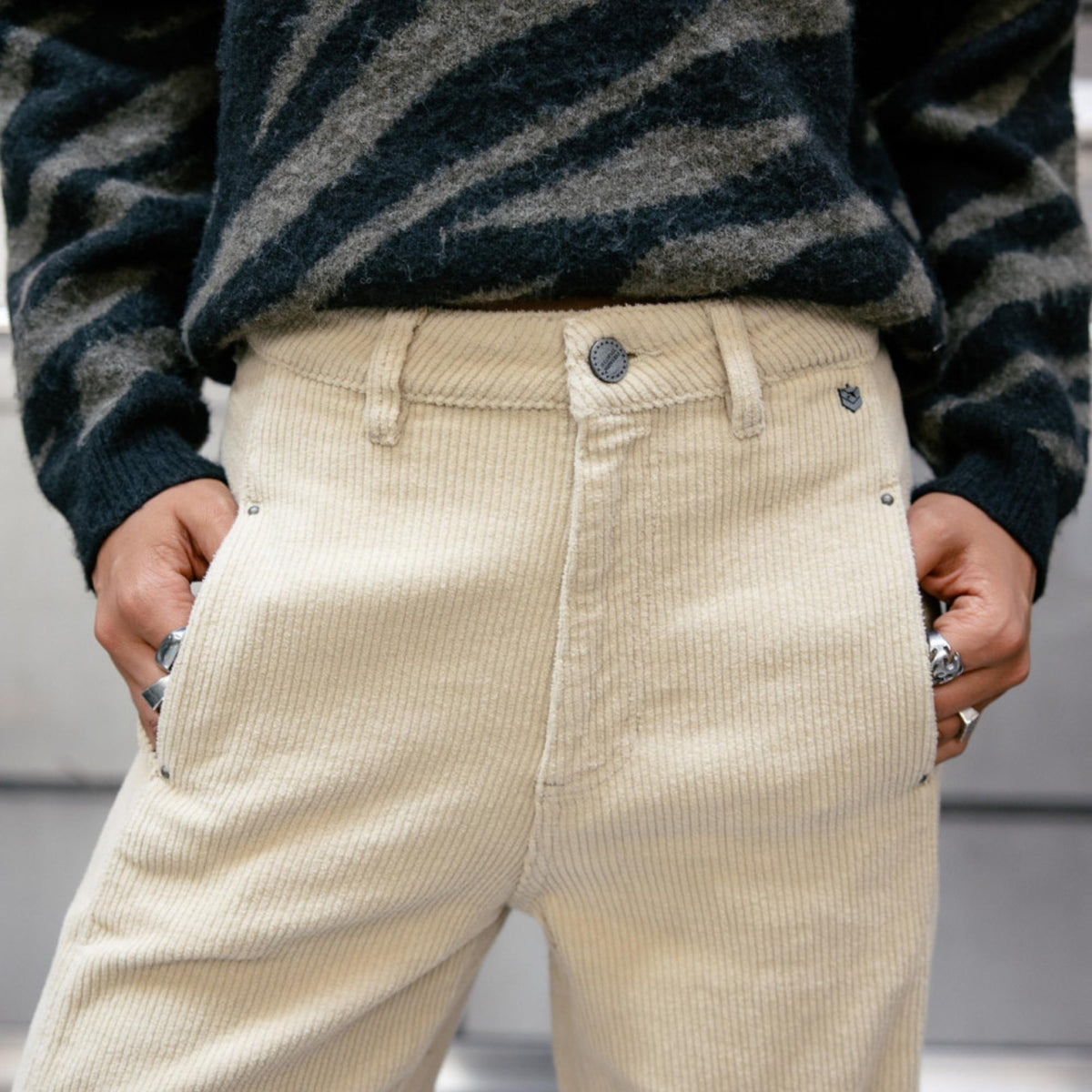 Gros plan sur la taille du pantalon Rosalia Veluto, bouton central, passants et texture côtelée.