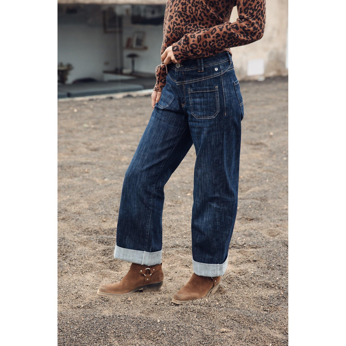 Vue trois-quarts arrière du jeans bleu indigo, poches plaquées et coupe ample légèrement raccourcie