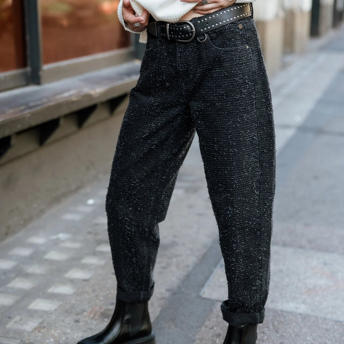 Silhouette de trois quarts en jean noir surfwear, volume généreux aux cuisses puis resserré vers les chevilles