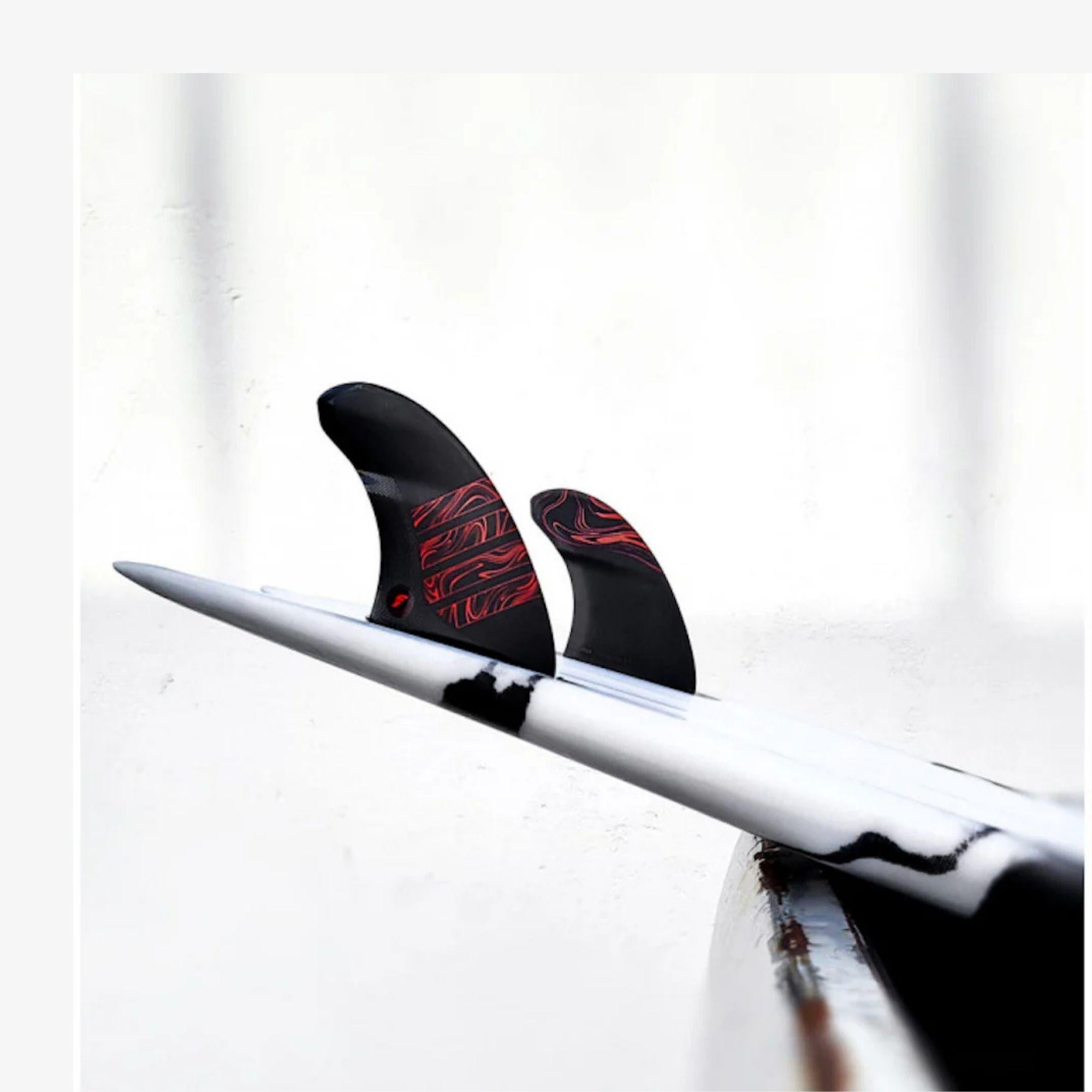 derives de surf noires et rouge futures montes sur planche de surf