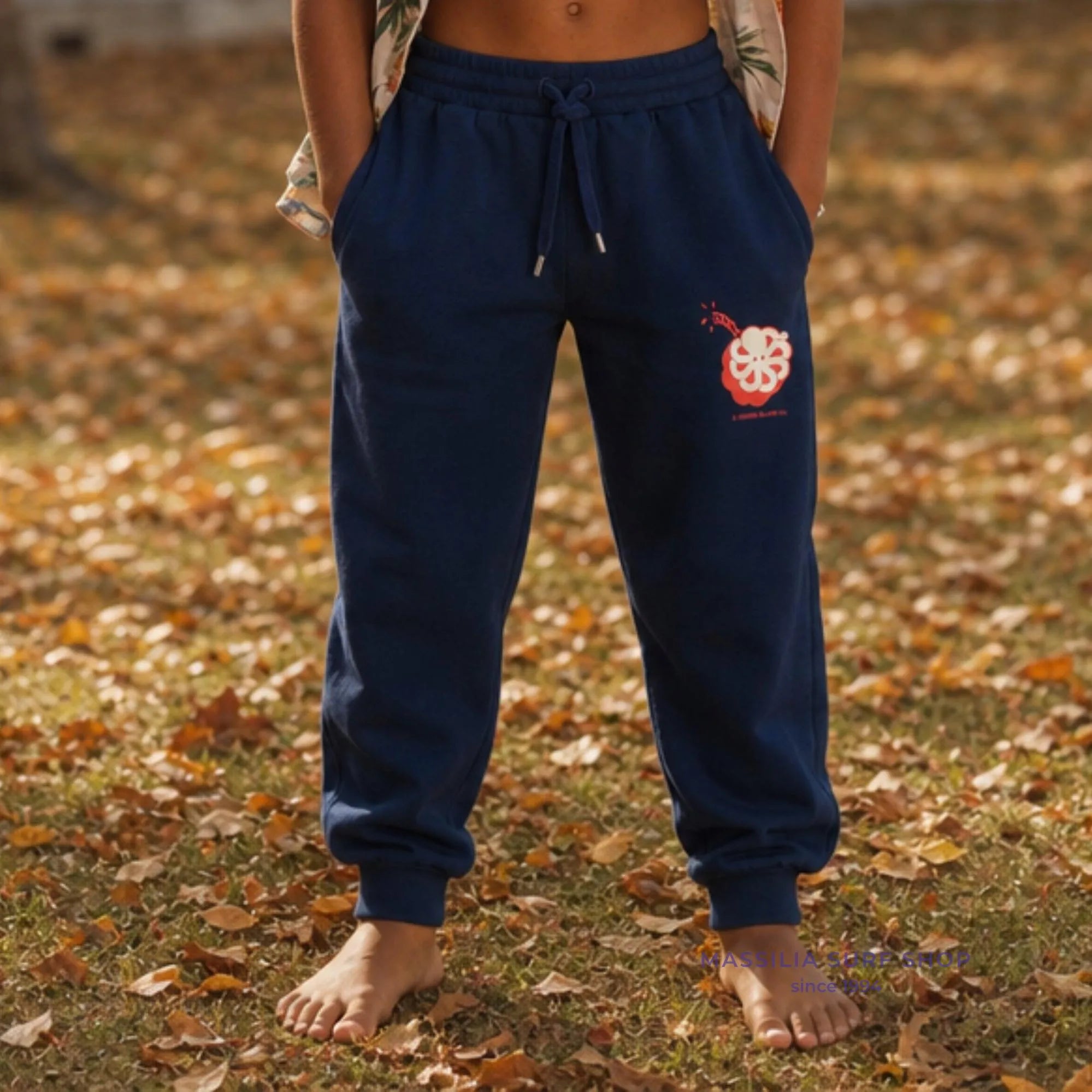 Jogging enfant surfwear Big Boom bleu marine porté de face, taille à cordon et grand poulpe en forme d'explosif drole corail imprimé sur la cuisse