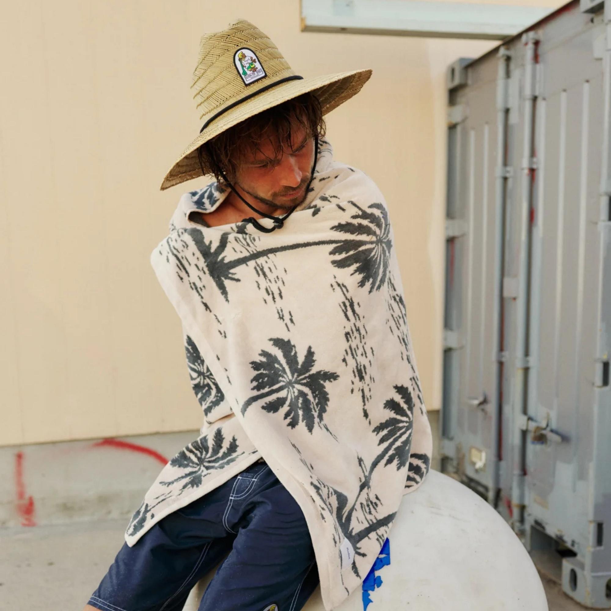 lifestyle homme avec serviette de plage et boardshort de surf