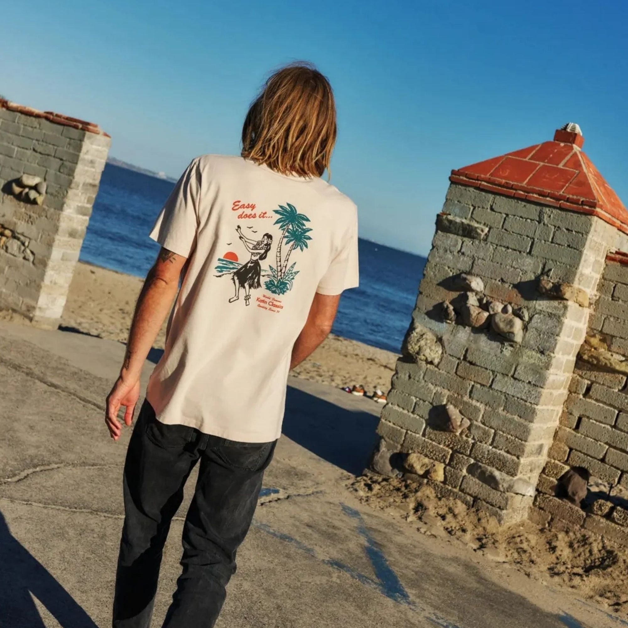 lifestyle porte par homme avec plage en arriere plan