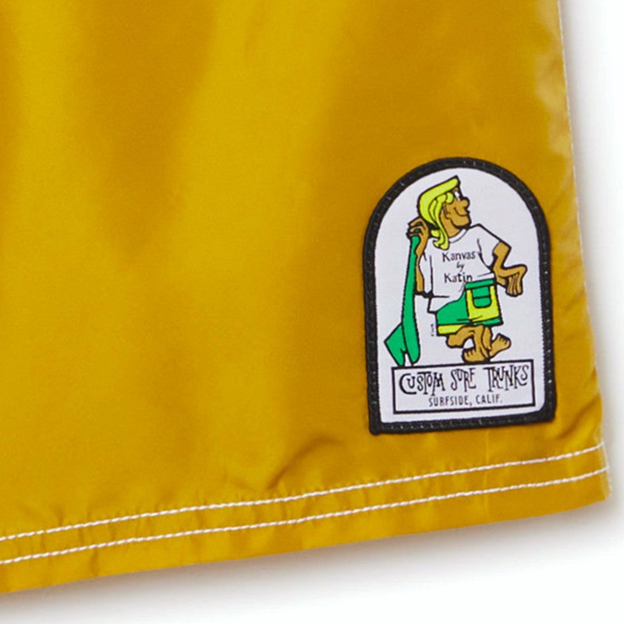 Détail patch brodé boardshort homme Katin Waterman Trunk jaune logo Custom Surf Trunks Surfside Calif