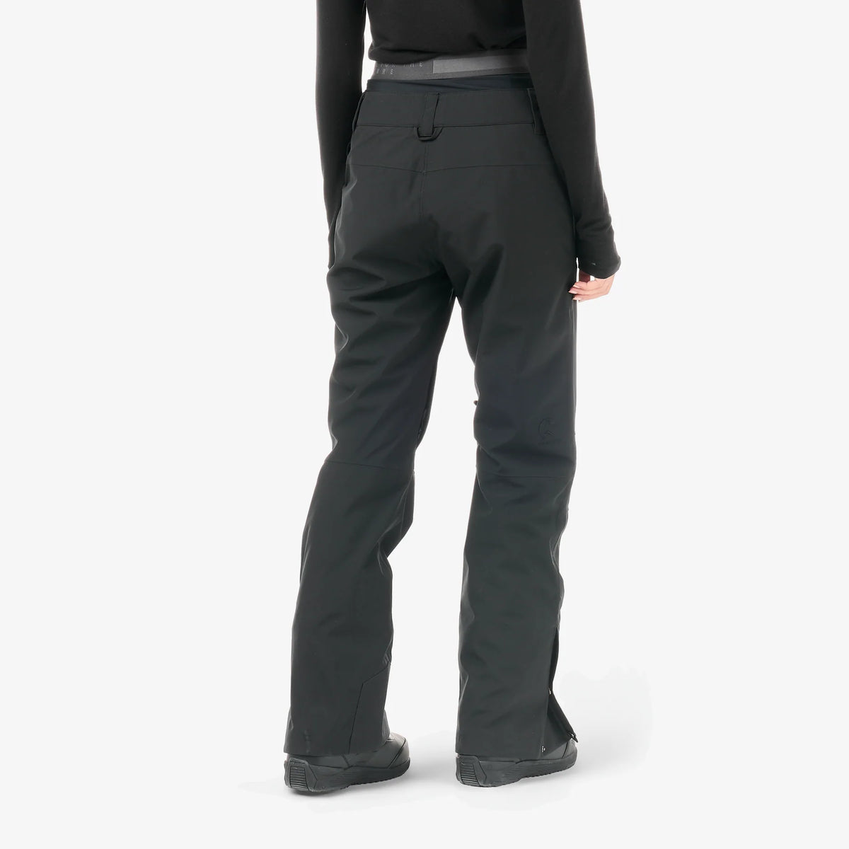 Vue arrière du pantalon Picture Exa Black porté, jambes droites et bas ajusté sur des boots de neige