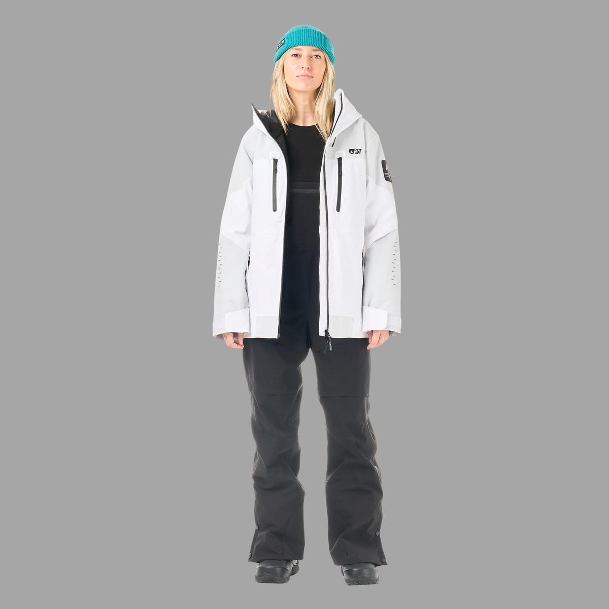 Veste de ski et snowboard femme Picture Orakoon JKT Brillant White portée en pied avec pantalon noir