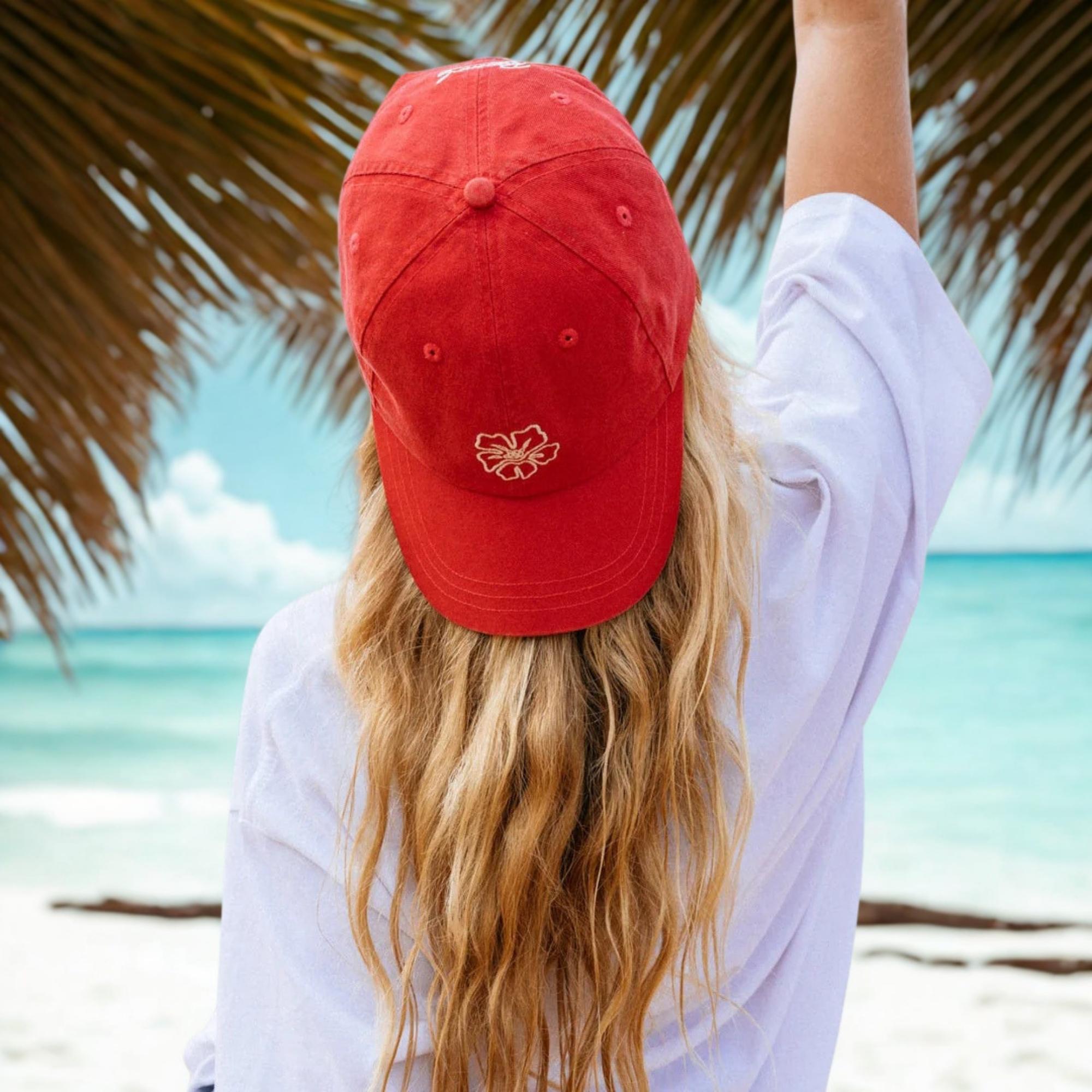 femme vue de dos sur une plage avec casquette rouge
