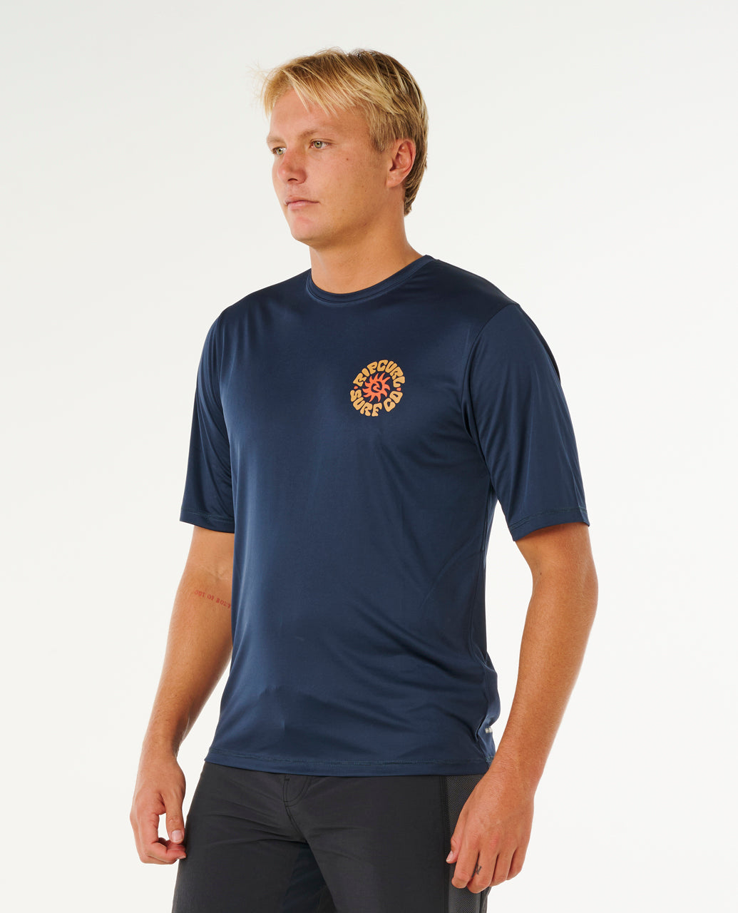 Tee-shirt lycra Rip Curl Pacific Rinse Navy porté de trois-quarts avec logo poitrine contrasté