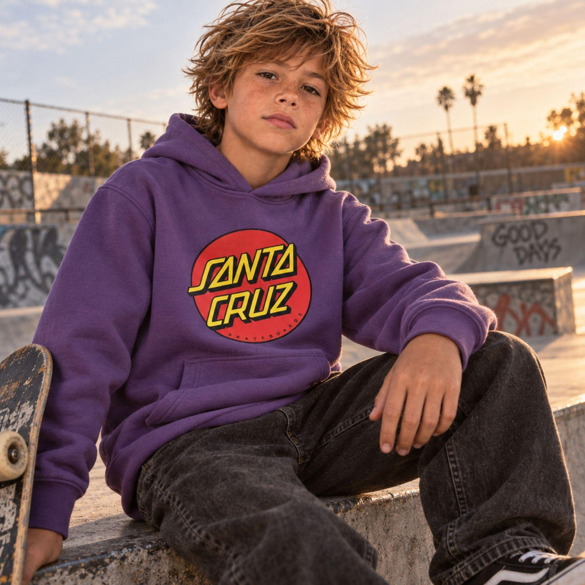 Sweat à capuche surfwear Santa Cruz Classic Dot Fresh Purple porté au skatepark, logo circulaire rouge, jaune et noir sur la poitrine