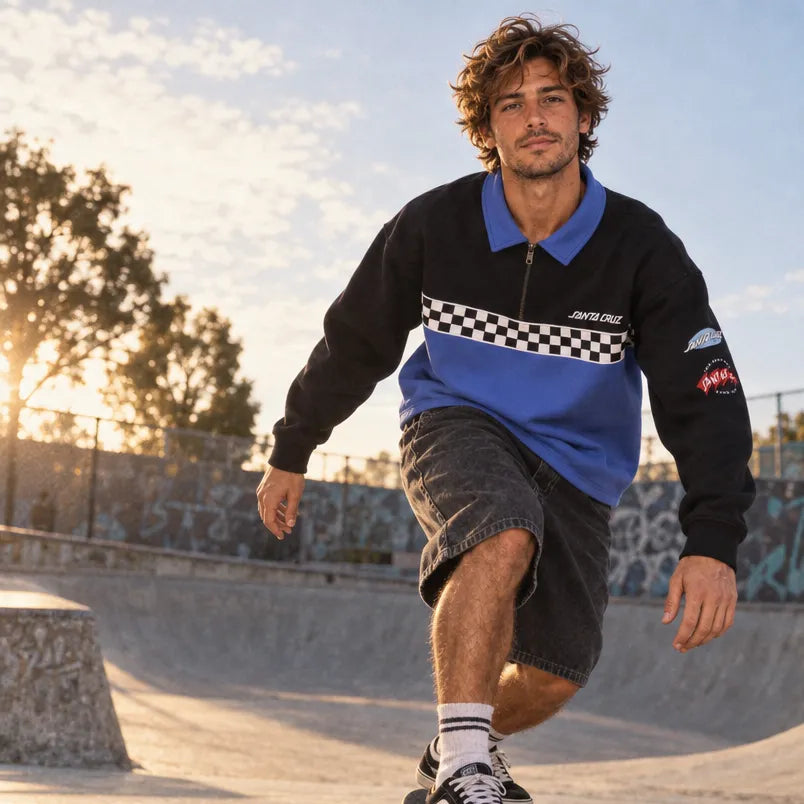 Skateur portant le sweatshirt Santa Cruz Podium Black/Sapphire de face dans un skatepark au coucher du soleil