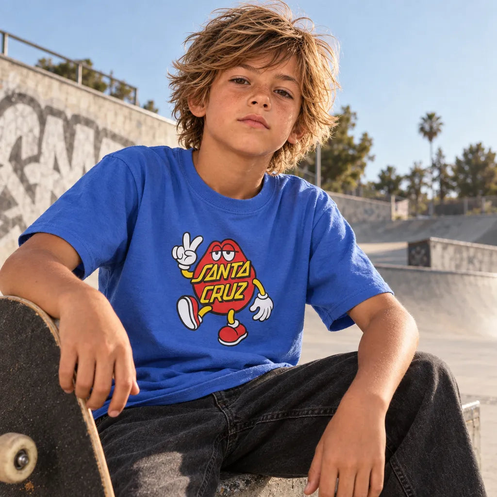 Jeune skateur assis avec planche de skate portant le t-shirt Santa Cruz Dot Guy Sapphire au skatepark de face