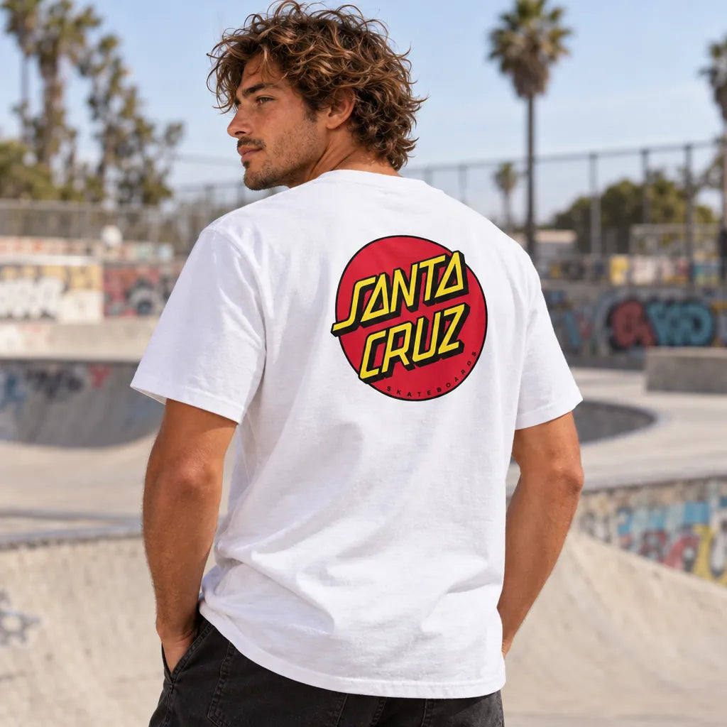 Homme portant le tee-shirt blanc Santa Cruz Classic Dot, vue de dos dans un skatepark californien bordé de palmiers