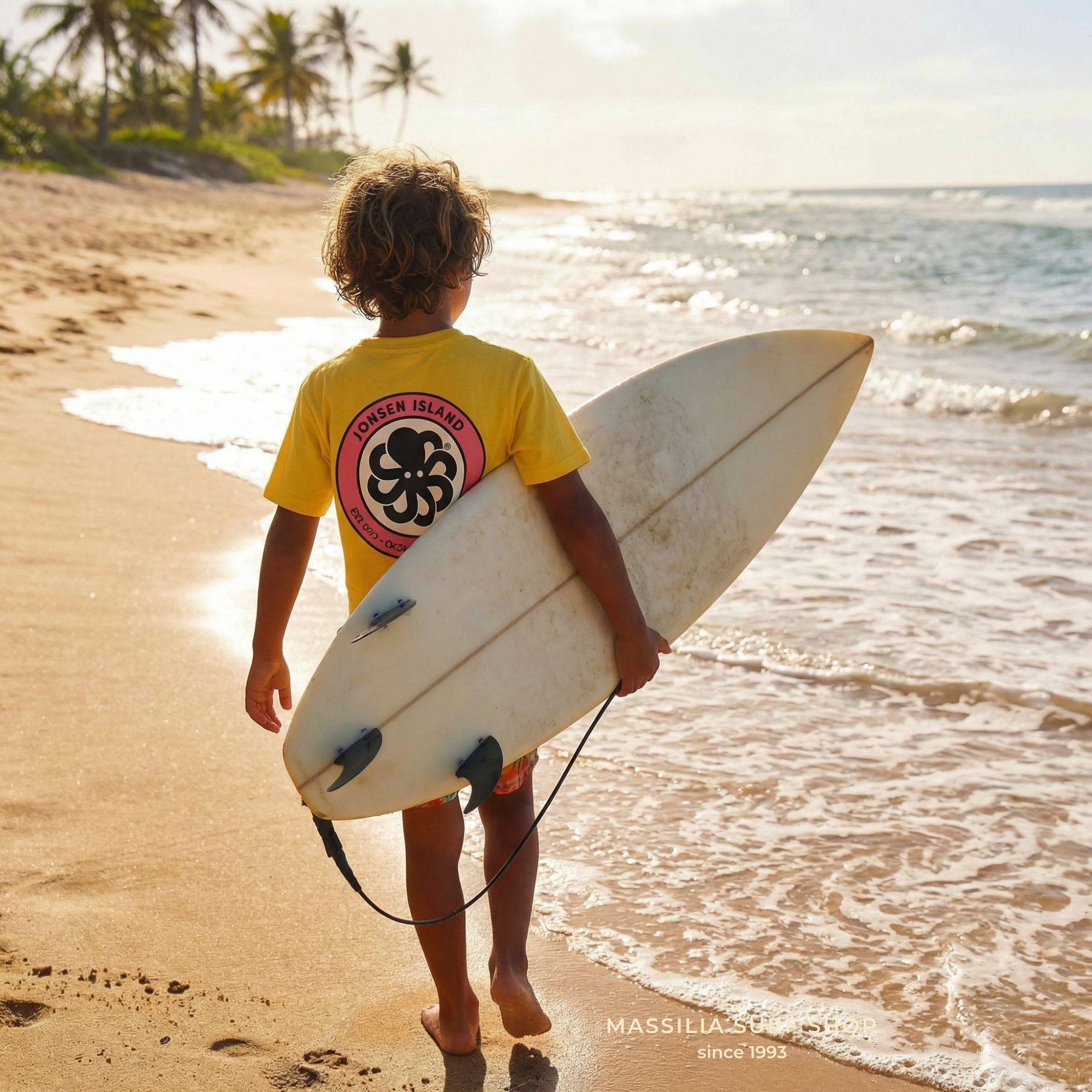 tee shirt jaune enfant jonsen island parte par garcon de 6 ans sur la plage avec surf sous le bras