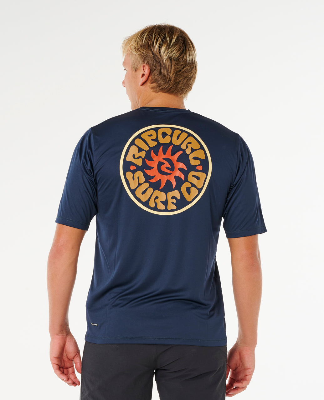 Tee-shirt lycra Rip Curl Pacific Rinse Navy porté en silhouette complète, coupe non moulante pour les sessions au soleil