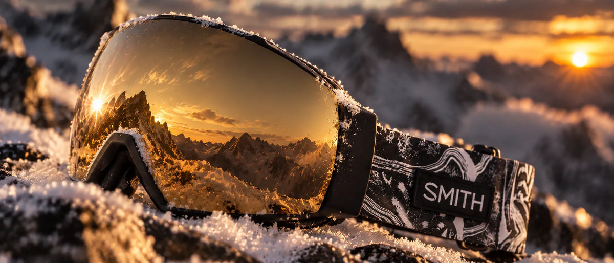 masque de neige smith posé sur la neige avec reflet de la montagne dans l'écran