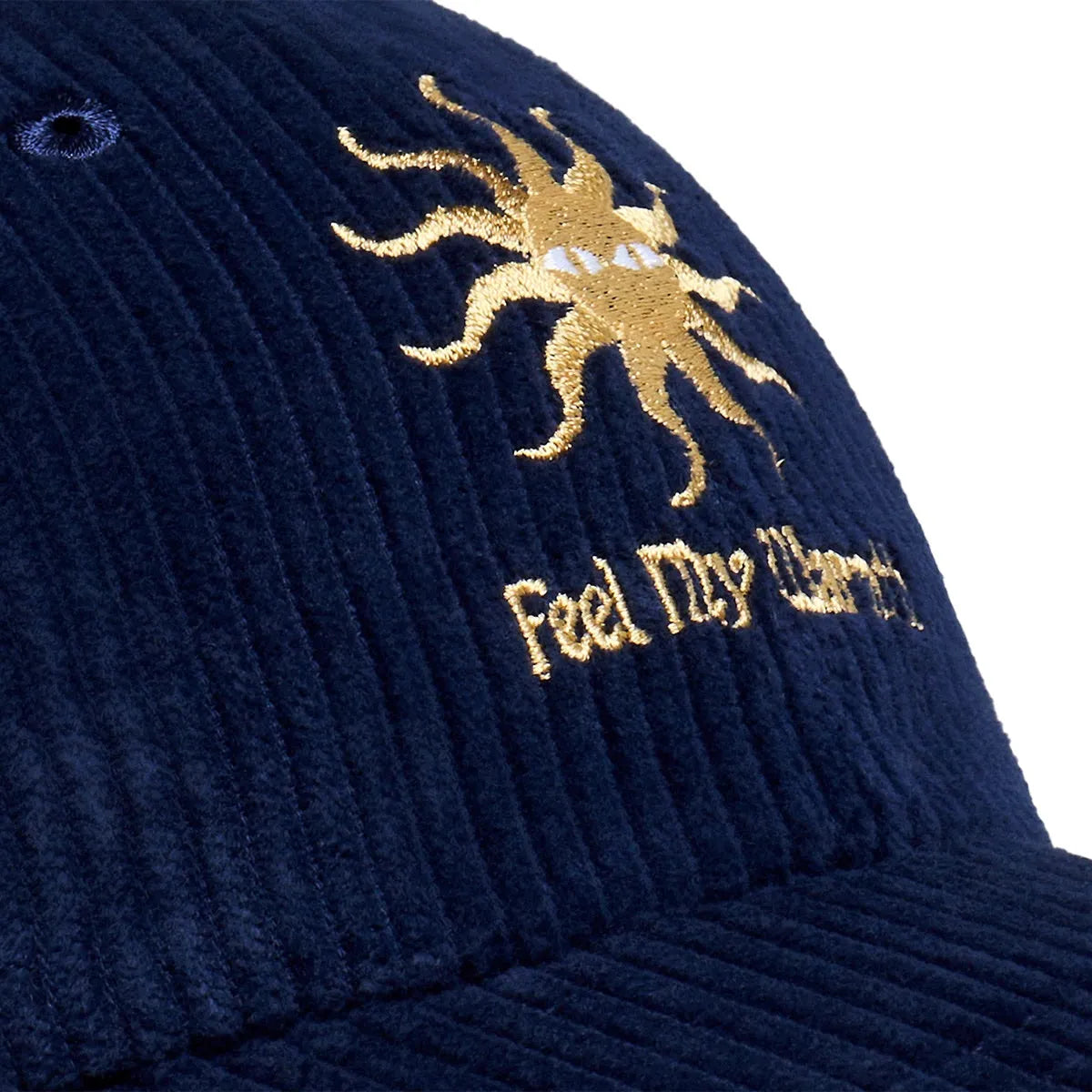 Détail de la broderie jaune représentant un soleil stylisé et du texte Feel The Warmth sur la casquette Bask in the Sun