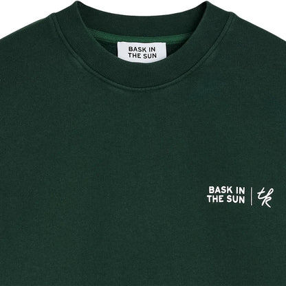 Détail du col rond et du marquage Free as the Sun sur la poitrine du sweatshirt Bask in the Sun Forest