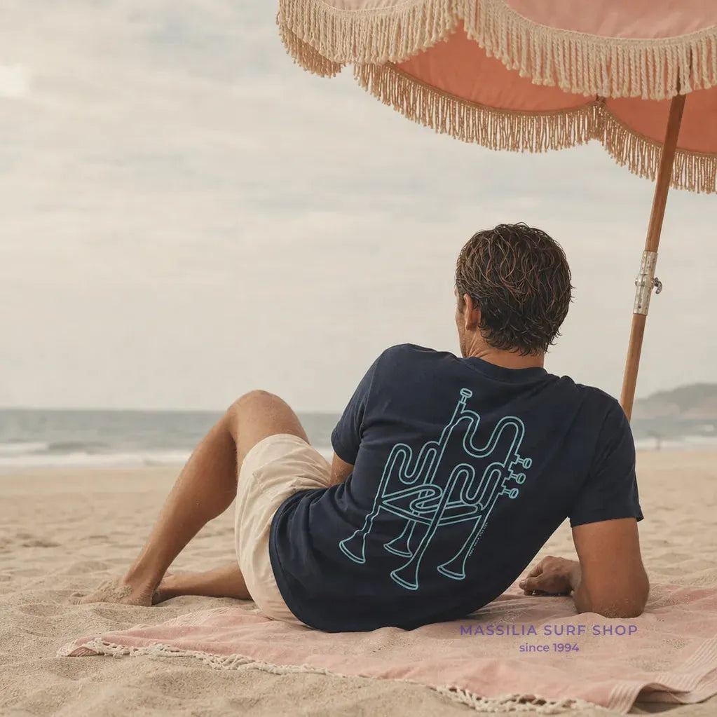 tee shirt trumpet bleu marine avec trompette stylisée turquoise dans le dos  porté par un homme