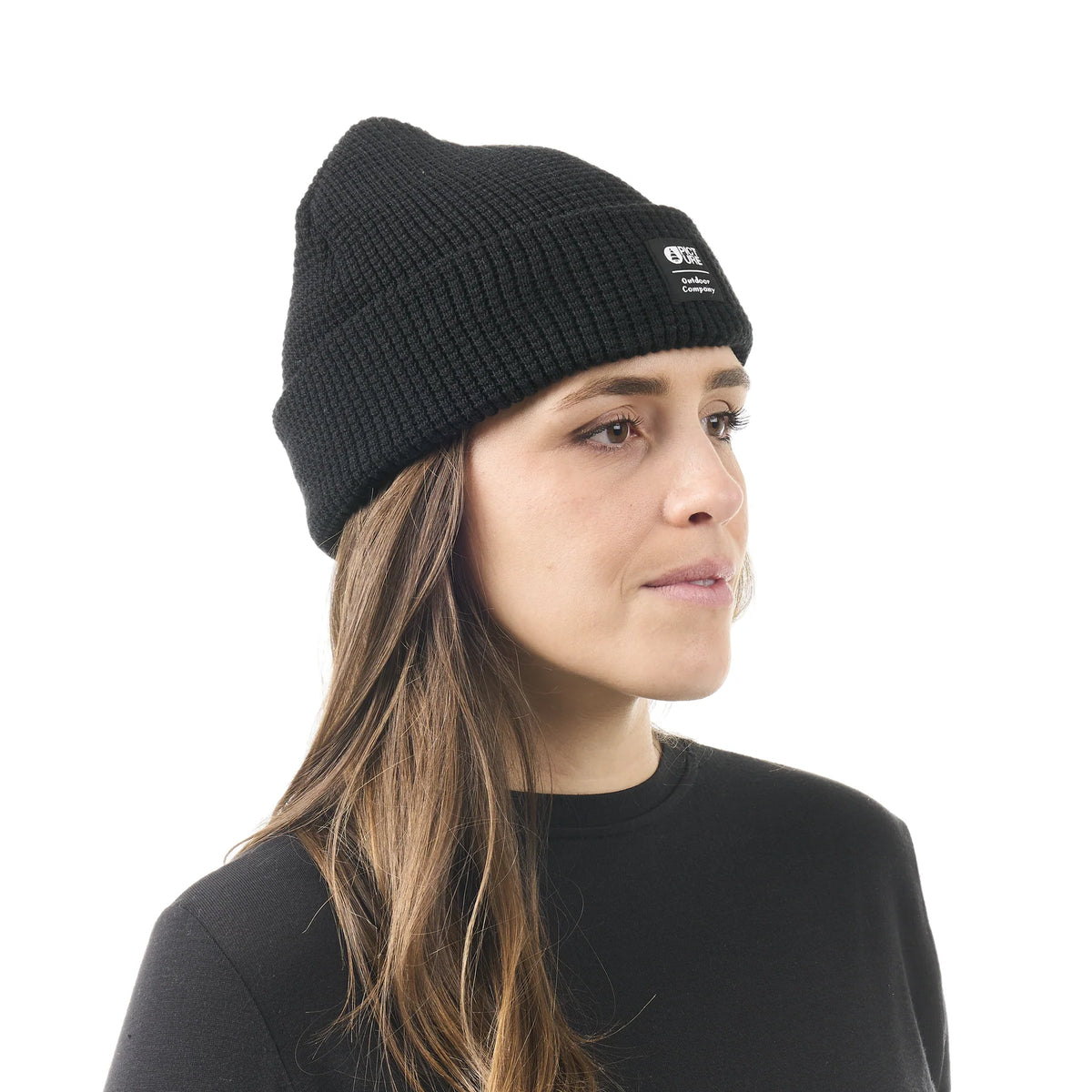 Bonnet unisexe Picture Organic Clothing York Beanie Black porté de face, maille texturée noire et étiquette logo sur le revers

