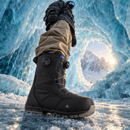 Boots snowboard homme Burton Ruler BOA Wide noires en profil latéral, avec deux molettes de serrage et chaussant large visible dans une cave de glace