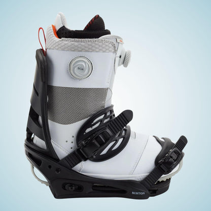 Boots de snowboard blanche et noire installée dans la fixation Mission, vue de trois quarts avec straps serrés