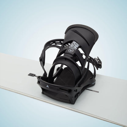 Fixation Burton Mission Re:Flex Black montée sur un snowboard clair, vue de trois quarts avec spoiler relevé