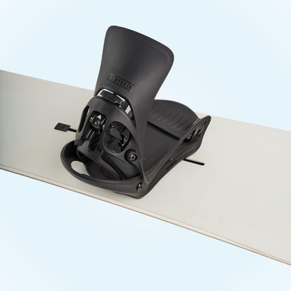 Fixation Burton Step On Cartel X Black montée sur un snowboard clair, vue de trois quarts avec spoiler relevé
