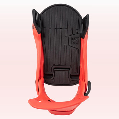 Fixation snowboard vue du dessus, avec embase noire matelassée, structure orange et espace dégagé pour la boots