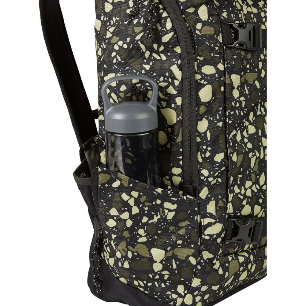 Vue latérale du sac Burton avec poche zippée, sangles noires et motif camouflage vert sur fond sombre et porte gourde extérieur