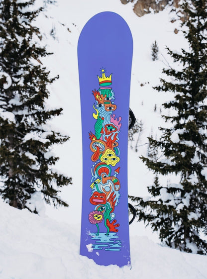 snowboard planté dans la neige vue semelle violette et dessin multicolore