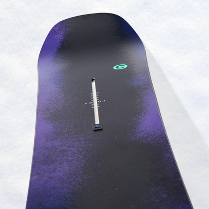 Nose du snowboard Burton vu en plongée, surface violet profond, spatule arrondie et petit repère vert contrastant