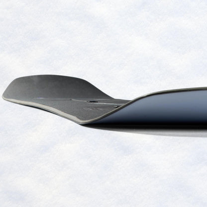 Carre du snowboard vue de profil, révélant la spatule relevée et la superposition des teintes noire, grise et lilas