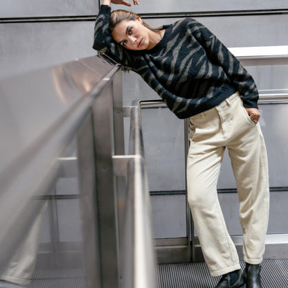Pantalon femme Freeman T. Porter Rosalia Veluto beige crème porté avec un pull rayé, coupe ample et jambes légèrement resserrées.