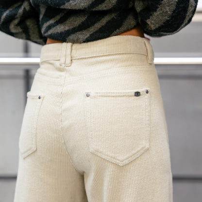 Vue arrière rapprochée du pantalon beige crème avec deux poches plaquées et coutures apparentes.