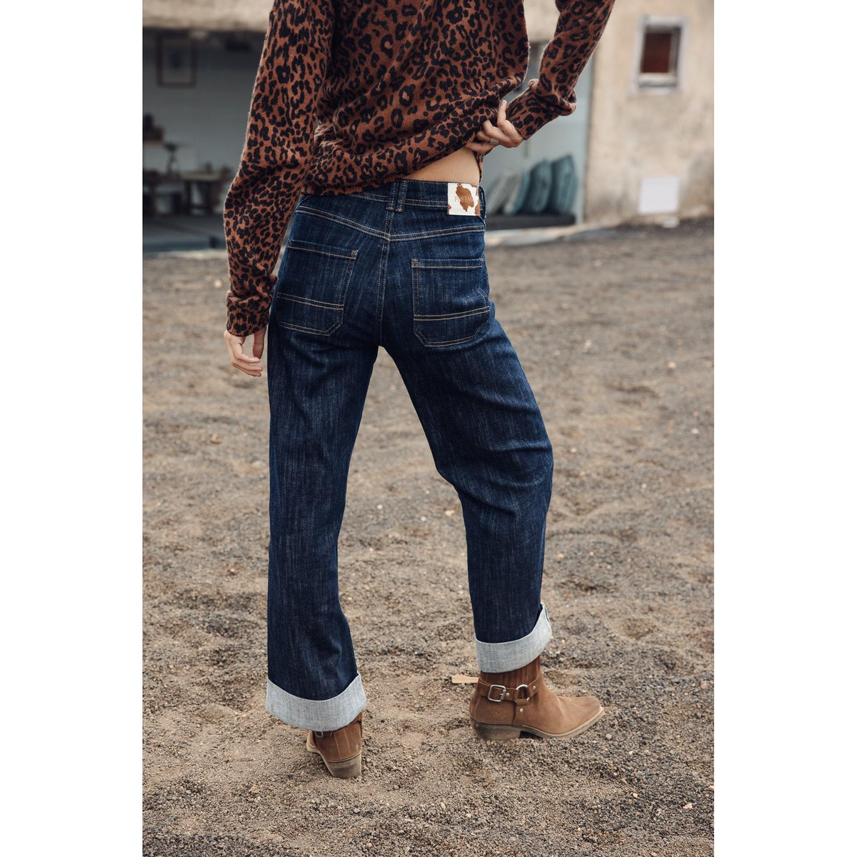 Jeans large 7/8 porté de dos avec haut léopard, volume ample sur les jambes et revers aux chevilles