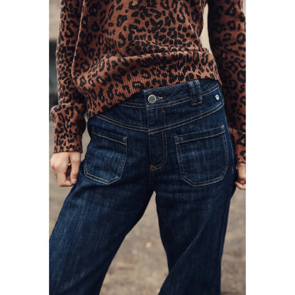 Gros plan sur les poches avant plaquées du jeans, denim indigo et surpiqûres camel contrastantes
