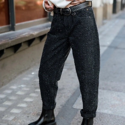 Silhouette de trois quarts en jean noir surfwear, volume généreux aux cuisses puis resserré vers les chevilles