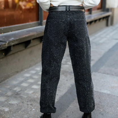 Dos du pantalon noir à effet moucheté, coupe ample structurée par deux poches plaquées et une taille ajustée