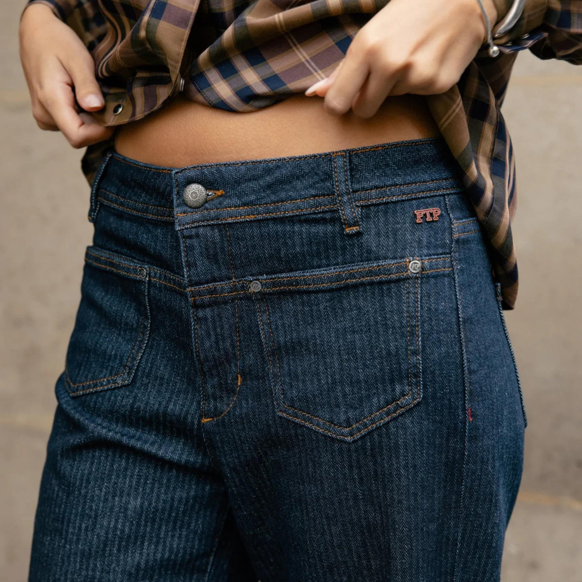 Gros plan sur la taille arrière du jean Freeman T. Porter, poches plaquées, coutures contrastées et petits détails rouges.