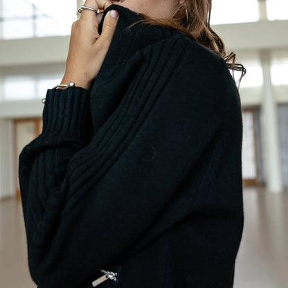 Silhouette de profil en Pelson Black, col rond épais et coupe courte accompagnée d’une poche zippée argentée