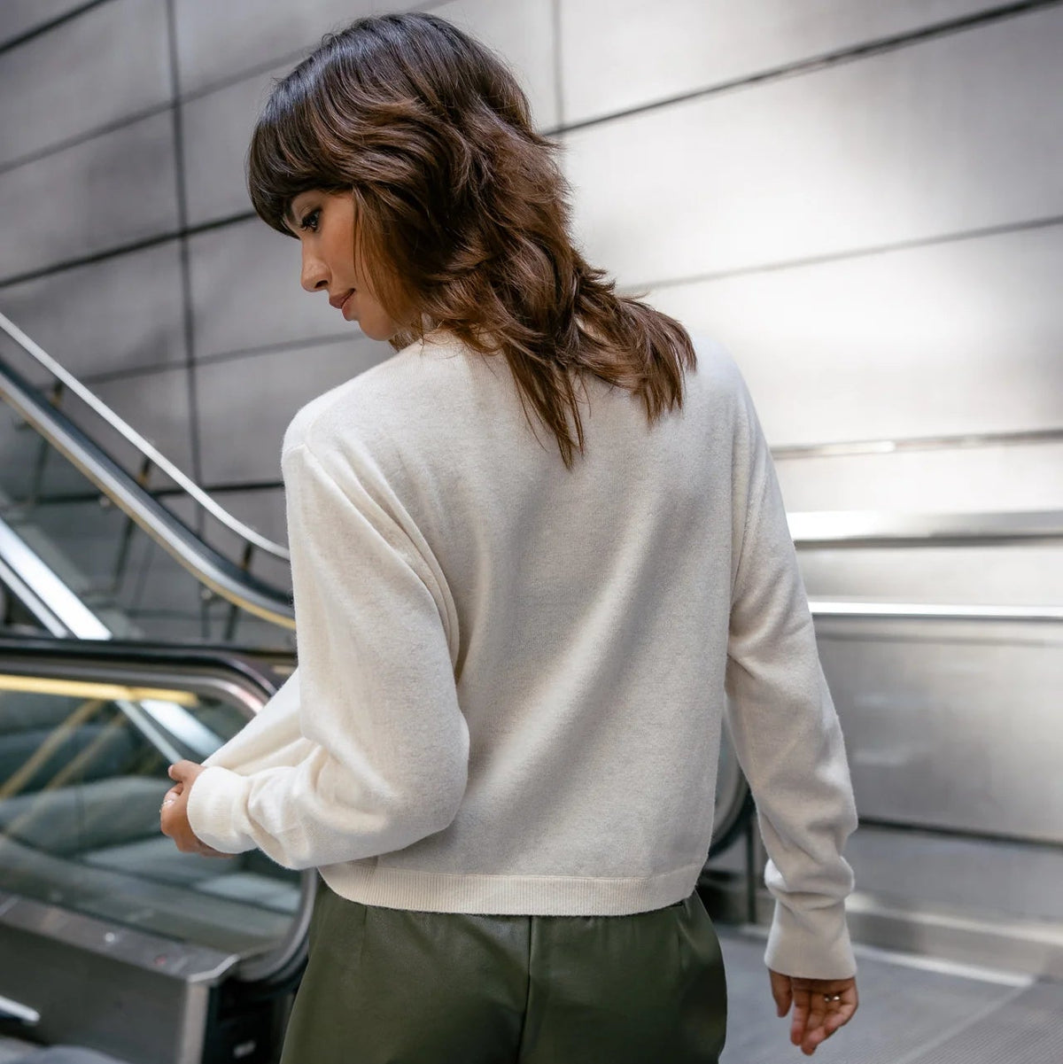 Porté de profil, le pull Pharos écru révèle son volume ample, ses manches longues et sa longueur légèrement courte