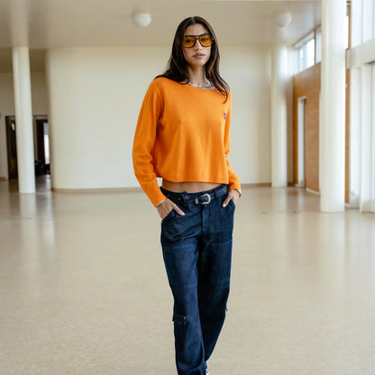 Vue en pied du Pharos Freeman T. Porter, coupe boxy orange vif associée à un jean bleu foncé