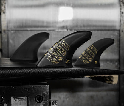 derives de surf noires avec bandes dorées futures fins alpha vector montées sur planche de surf noire