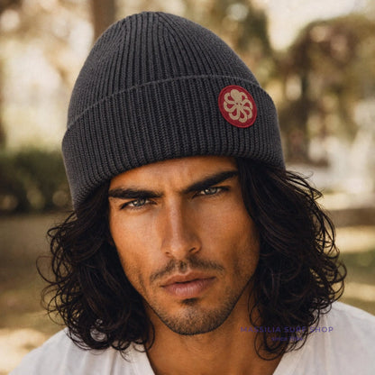 Accessoire surfwear Jonsen Island gris anthracite porté par un homme, maille côtelée et médaillon pieuvre rouge sur le revers